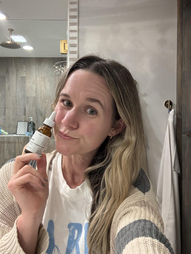 Woman applying squalane for acne as first cleansing step with clear glowing skin